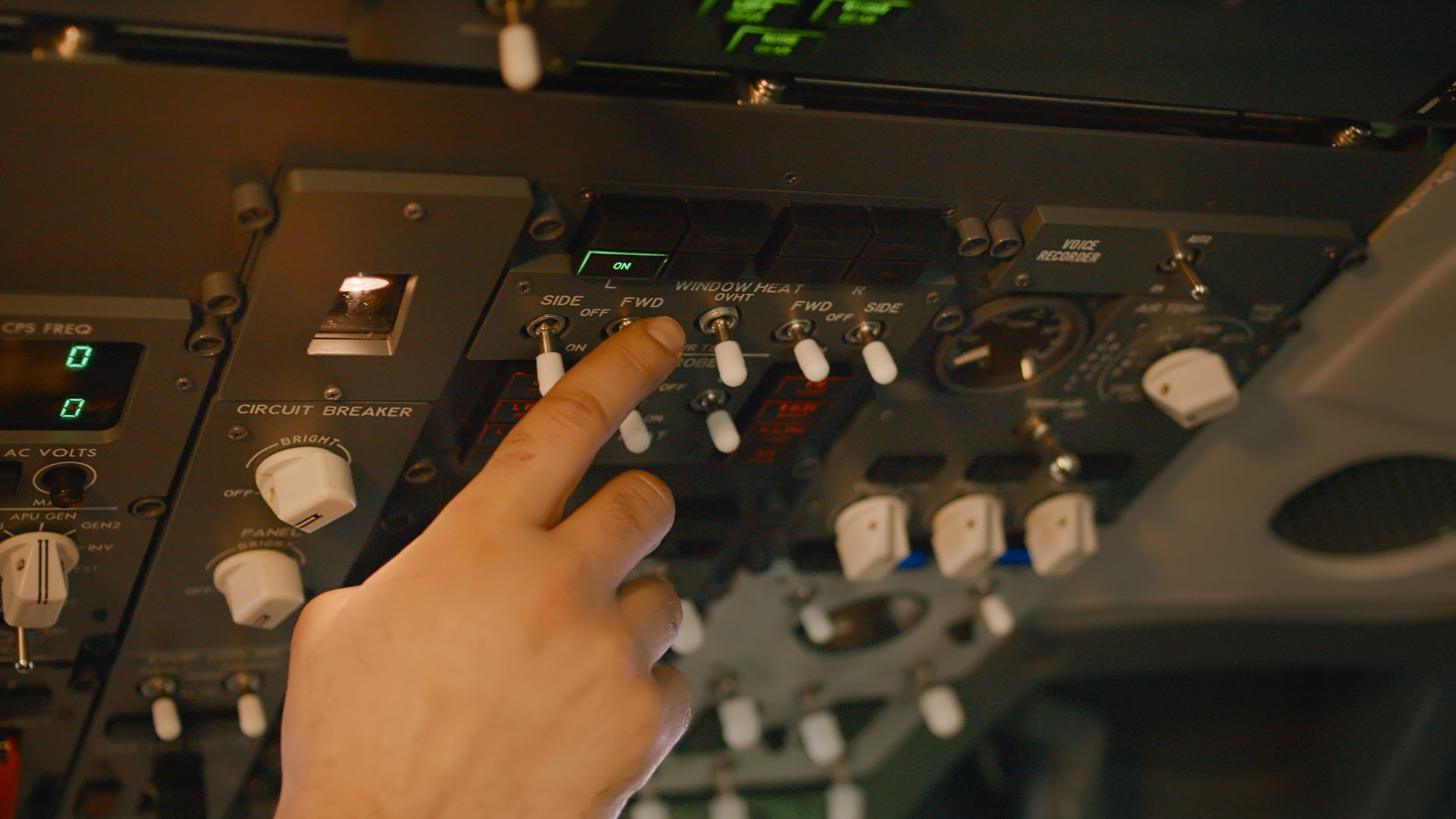 Hand on an aircraft systems panel
